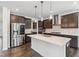 Modern kitchen featuring a large island, stainless steel appliances, and dark wood cabinets at 1177 Sun Springs Rd, Wake Forest, NC 27587