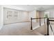 Upstairs loft area filled with natural light, carpet floors, and a staircase with dark wooden handrail at 1177 Sun Springs Rd, Wake Forest, NC 27587