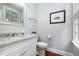 Well-lit powder room with a marble countertop vanity, framed mirror, and hardwood flooring at 119 Palace Grn, Cary, NC 27518