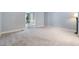 Light-filled bedroom with plush carpet, neutral paint, and an open doorway at 119 Palace Grn, Cary, NC 27518