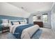 Bright primary bedroom with a large bed, blue accent wall, and carpeted floors at 119 Palace Grn, Cary, NC 27518