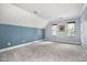 Bright bedroom with a blue accent wall, neutral carpet, and two windows at 119 Palace Grn, Cary, NC 27518