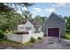 Exterior showcasing a cozy home with a white picket fence and detached garage with a striking plum garage door at 119 Palace Grn, Cary, NC 27518