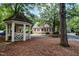Exterior view of the home with cedar shake roof with red shutters and a gazebo nearby at 119 Palace Grn, Cary, NC 27518