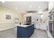 Bright kitchen with white cabinets and stainless steel appliances, centered around a blue island at 119 Palace Grn, Cary, NC 27518