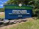 Entrance sign for Hemlock Bluffs Nature Preserve under a clear sky at 119 Palace Grn, Cary, NC 27518