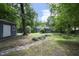 Lush backyard with a dry creek bed, storage shed, and mature trees at 120 Pine St, Carrboro, NC 27510