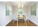 Bright dining room with a minimalist table set, wood floors, and natural light at 120 Pine St, Carrboro, NC 27510