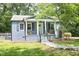 Quaint single Gathering home with a covered front porch, stone pathway, fresh grass and mature trees at 120 Pine St, Carrboro, NC 27510