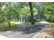 A well-maintained home with a long driveway surrounded by mature trees and lush greenery at 120 Pine St, Carrboro, NC 27510