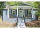 Charming home featuring a cozy front porch with seating and beautiful gray exterior with teal shutters at 120 Pine St, Carrboro, NC 27510