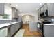 Well-lit kitchen boasts gray cabinets, stainless steel appliances, and a view to the dining room at 120 Pine St, Carrboro, NC 27510