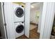 Convenient laundry closet with stacked washer and dryer adjacent to open home office area at 120 Pine St, Carrboro, NC 27510