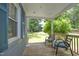 Relaxing covered front porch with seating, offering a peaceful view of the lush backyard at 120 Pine St, Carrboro, NC 27510