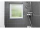 Updated gray tile shower with rainfall shower head and handheld shower fixture and window at 120 Pine St, Carrboro, NC 27510