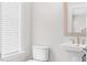 This half bathroom features a white pedestal sink, toilet, and window with blinds at 1203 Corkery Ridge Ct, Cary, NC 27519