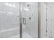 This walk-in shower features white and gray marble tiles, bench, and glass doors at 1203 Corkery Ridge Ct, Cary, NC 27519