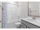 Bathroom featuring a sink with gray cabinets, a tub with shower, and a multicolored shower curtain at 1203 Corkery Ridge Ct, Cary, NC 27519