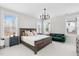 This primary bedroom features a dark wood bedframe, a green couch, and three windows at 1203 Corkery Ridge Ct, Cary, NC 27519
