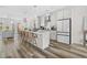 Spacious white kitchen with a large island, pendant lighting, stainless appliances, and hardwood floors, perfect for entertaining at 1203 Corkery Ridge Ct, Cary, NC 27519