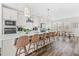 Bright, modern kitchen with white cabinetry, stainless steel appliances, a quartz countertop island, and seating for six at 1203 Corkery Ridge Ct, Cary, NC 27519