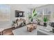 Bright, spacious living room featuring wood floors, stylish decor, plants, and large windows for abundant natural light at 1203 Corkery Ridge Ct, Cary, NC 27519