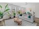 Comfortable living room featuring a couch, wood floors, potted plants, and large windows providing plenty of natural light at 1203 Corkery Ridge Ct, Cary, NC 27519