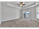 Bedroom featuring tray ceilings, carpeted floors, neutral walls and an outdoor patio accessible through sliding glass doors at 1217 Linkwood Way, Fuquay Varina, NC 27526