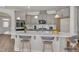 Staged kitchen with gray cabinets, white backsplash, a kitchen island with barstools and stainless steel appliances at 1217 Linkwood Way, Fuquay Varina, NC 27526