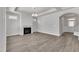 Living room area with hardwood floors, a fireplace, large windows and a modern chandelier at 1217 Linkwood Way, Fuquay Varina, NC 27526