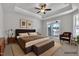 Bright main bedroom featuring tray ceilings, ceiling fan, and sliding glass doors to outdoor balcony at 1217 Linkwood Way, Fuquay Varina, NC 27526
