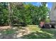The backyard has an expansive grassy area, mature trees, and a deck with a grill at 1304 Double Oak Ln, Willow Springs, NC 27592