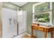 Shower with glass doors, window, and a decorative table for toiletries or decor at 1304 Double Oak Ln, Willow Springs, NC 27592