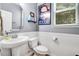 Well-lit bathroom with a white toilet, sink, framed artwork, and a large vanity mirror at 1304 Double Oak Ln, Willow Springs, NC 27592