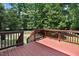 The home's wooden deck has dark railings and is elevated, with a view of the large backyard at 1304 Double Oak Ln, Willow Springs, NC 27592
