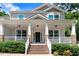 Inviting front porch with brick stairs, stone pillars, white railings, and a cozy space for relaxation at 1304 Double Oak Ln, Willow Springs, NC 27592