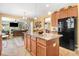 Bright, open kitchen with granite countertops, stainless steel refrigerator, and a breakfast bar with seating at 1304 Double Oak Ln, Willow Springs, NC 27592