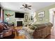 Comfortable living room featuring a fireplace, ceiling fan, and stairway to upper level at 1304 Double Oak Ln, Willow Springs, NC 27592