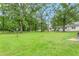 Large backyard featuring a green lawn, mature trees, and a shed at 1400 Roslyn Dr # 17B, Burlington, NC 27215