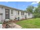 Backyard featuring a white painted brick home, green grass, and mature trees at 1400 Roslyn Dr # 17B, Burlington, NC 27215