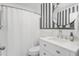 Stylish bathroom featuring black and white striped walls, a round mirror, and a white vanity at 1400 Roslyn Dr # 17B, Burlington, NC 27215