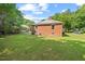 A well-maintained backyard with green grass and a brick home at 1411 Hudson Ave, Durham, NC 27705