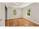 Bedroom features hardwood floors, two windows, and a neutral color palette at 1411 Hudson Ave, Durham, NC 27705