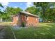 A brick home with a well-kept lawn, a small porch, and visible utilities at 1411 Hudson Ave, Durham, NC 27705