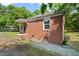 Cozy brick home featuring a small porch and well-maintained surroundings at 1411 Hudson Ave, Durham, NC 27705