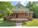 Charming brick home featuring a cozy front porch and traditional design at 1411 Hudson Ave, Durham, NC 27705