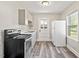 Well-lit kitchen featuring modern appliances, gray cabinets, and vinyl flooring at 1411 Hudson Ave, Durham, NC 27705