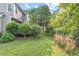 Backyard featuring a well-maintained lawn, lush landscaping, and deck with outdoor seating at 1504 Haventree Rd, Durham, NC 27713