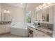 Bright bathroom featuring double vanity with granite counters, soaking tub and garden window at 1504 Haventree Rd, Durham, NC 27713