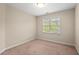 Bedroom with carpet flooring and large window showcasing the neighborhood view at 1504 Haventree Rd, Durham, NC 27713
